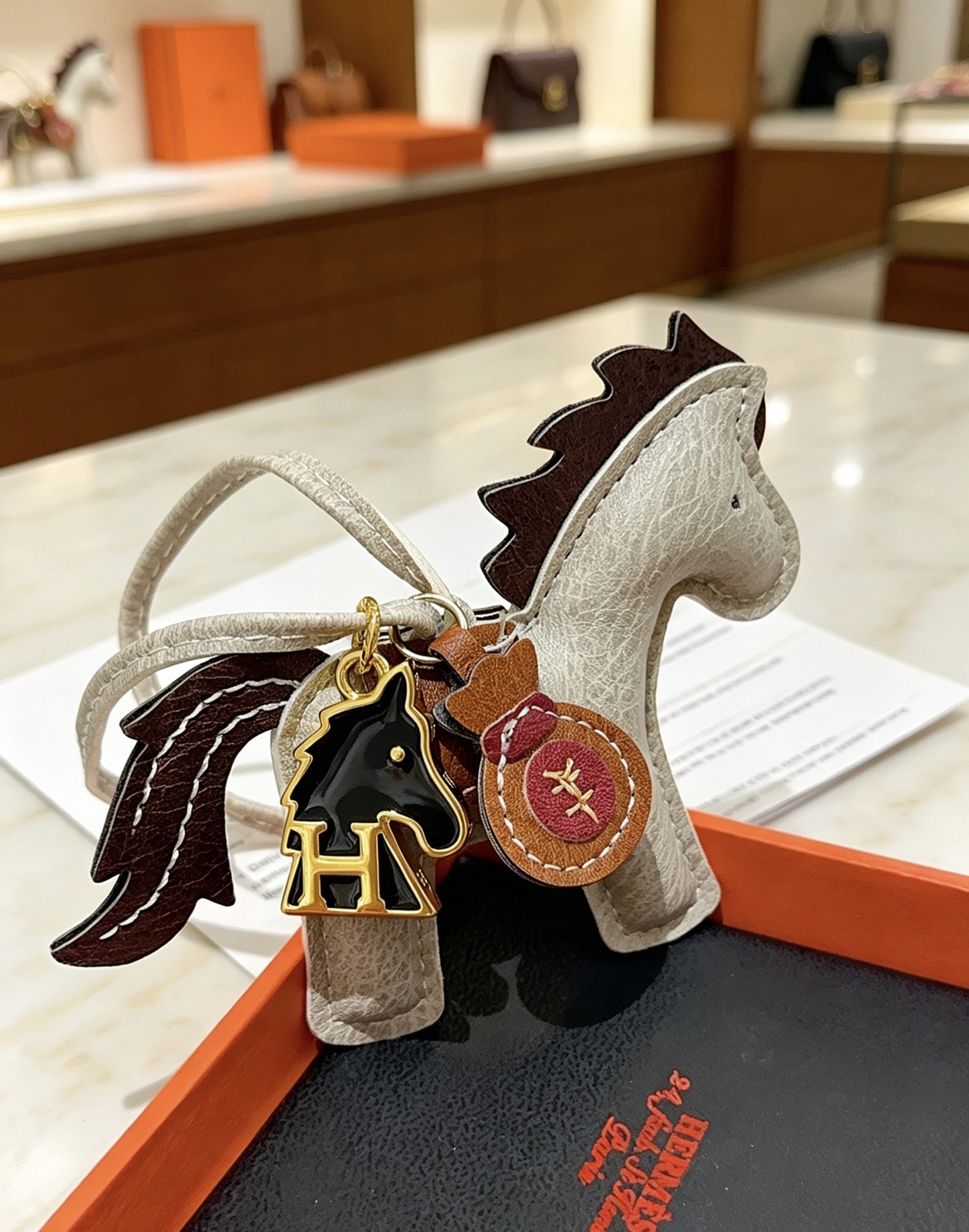 Ciondolo Hermes Rodeo Pegase Horse Bag Charm in pelle grigio chiaro con coda di criniera in pelle marrone scuro, sella in pelle marrone chiaro, hardware in metallo color oro, smalto nero, H cavallo, ciondolo per borsa di denaro in pelle bordeaux, ciondolo da 8 cm con cinturino in pelle da 12 cm.