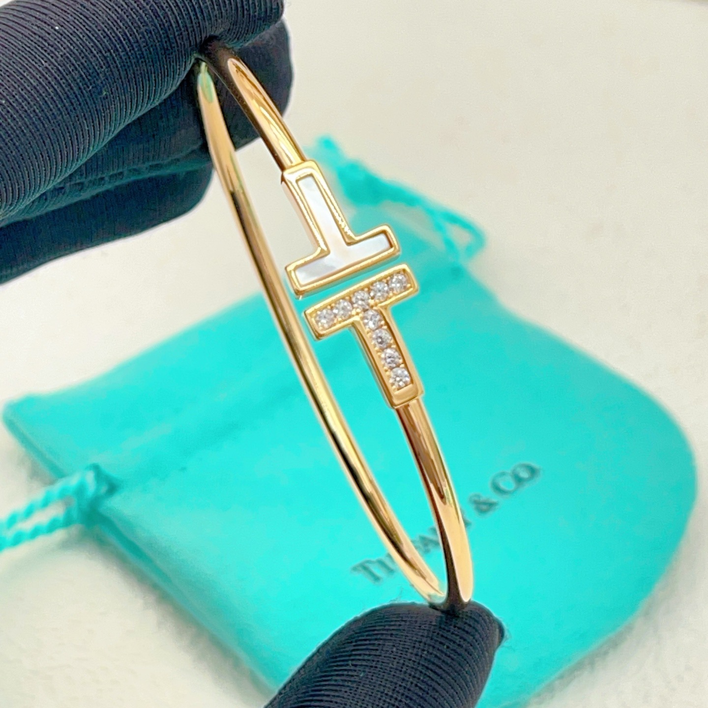 Tiffany Co T Wire bracelet yellow gold metal with white mother-of-pearl and clear diamond accents 17cm inner circumference