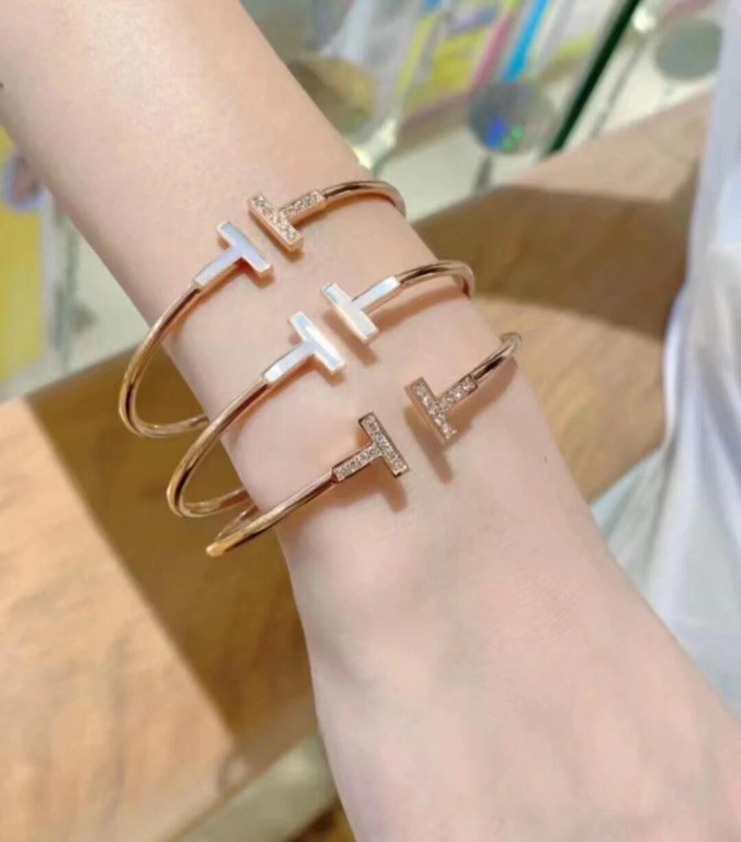 Tiffany Co T Wire bracelet yellow gold metal with white mother-of-pearl and clear diamond accents 17cm inner circumference