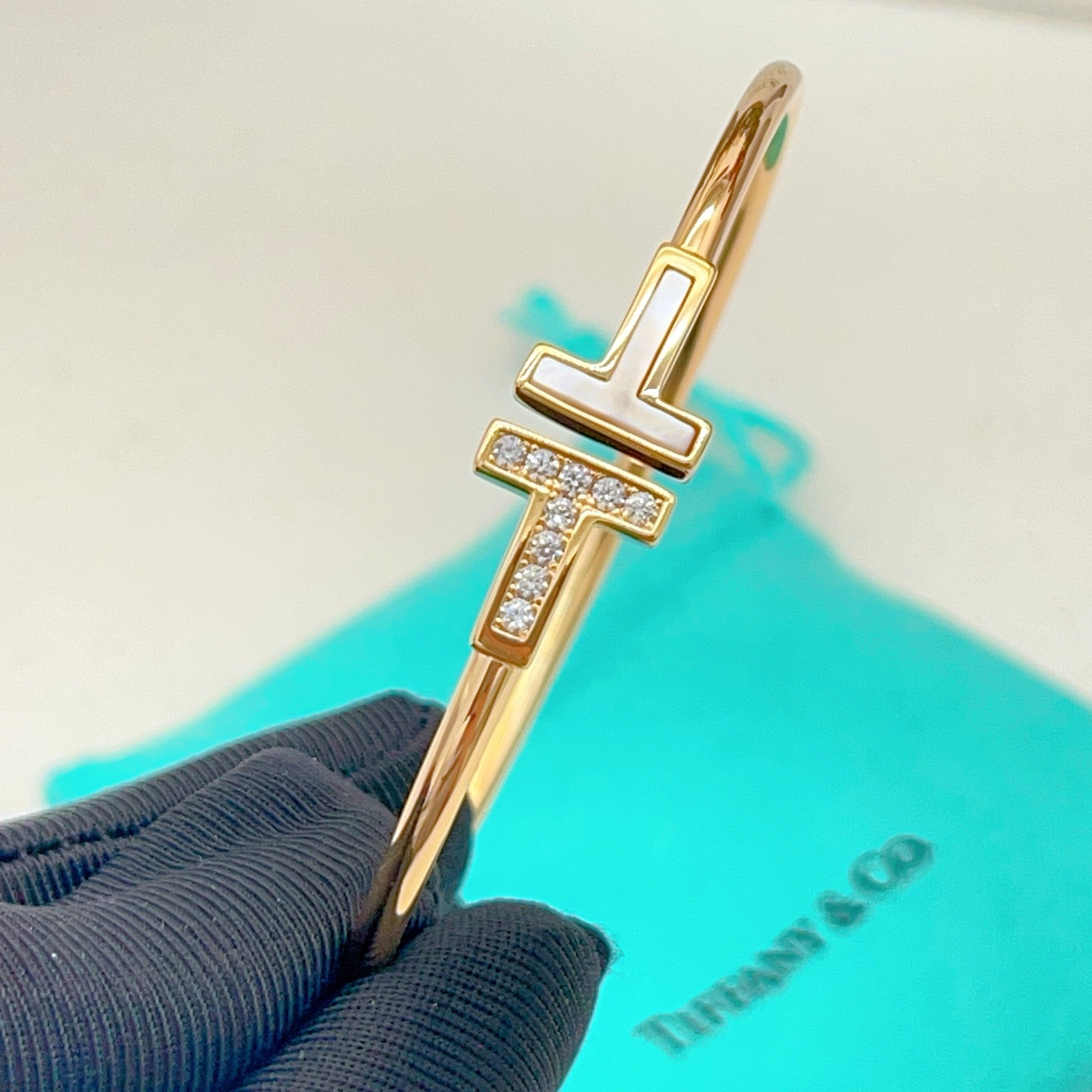 Tiffany Co T Wire bracelet yellow gold metal with white mother-of-pearl and clear diamond accents 17cm inner circumference