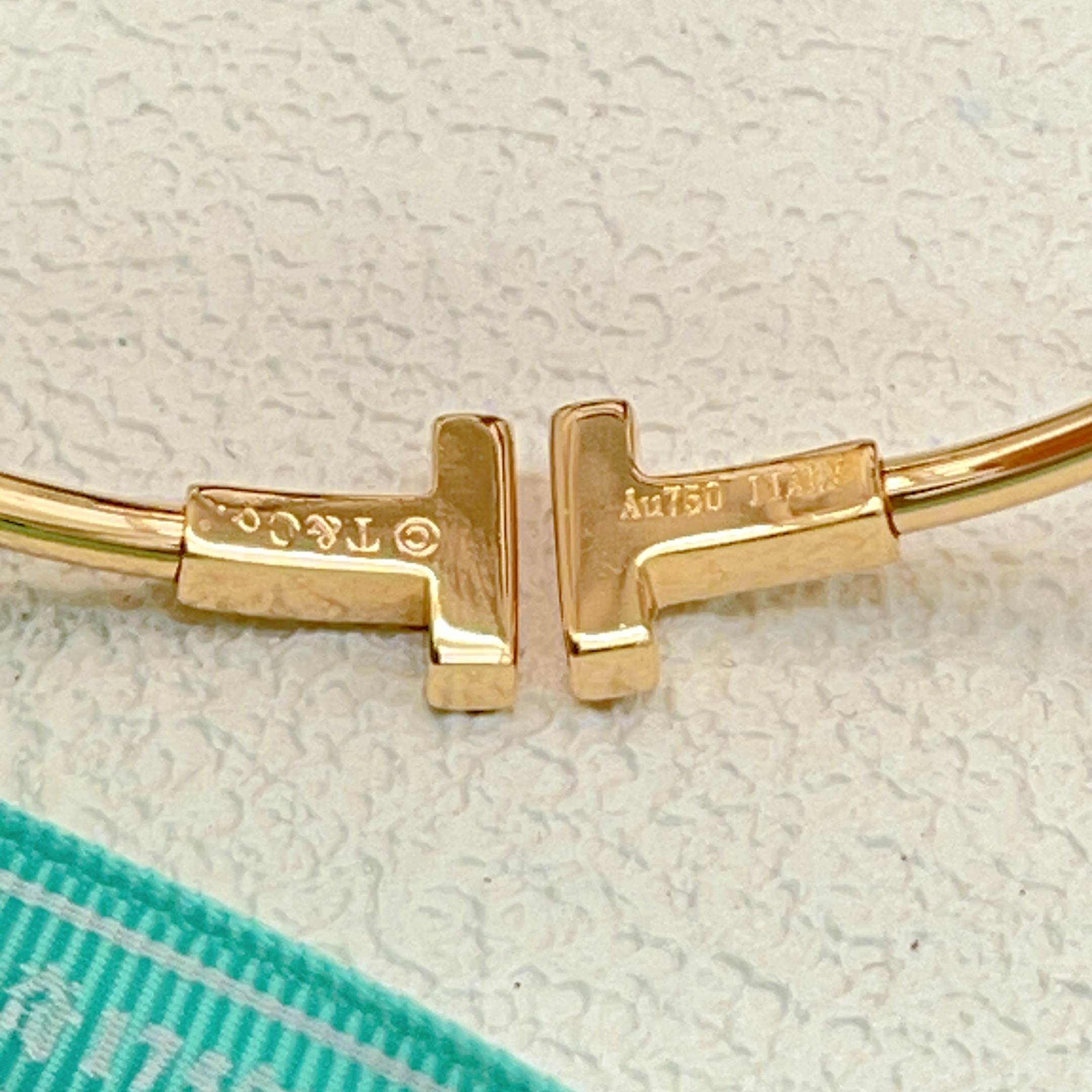 Tiffany Co T Wire bracelet yellow gold metal with white mother-of-pearl and clear diamond accents 17cm inner circumference