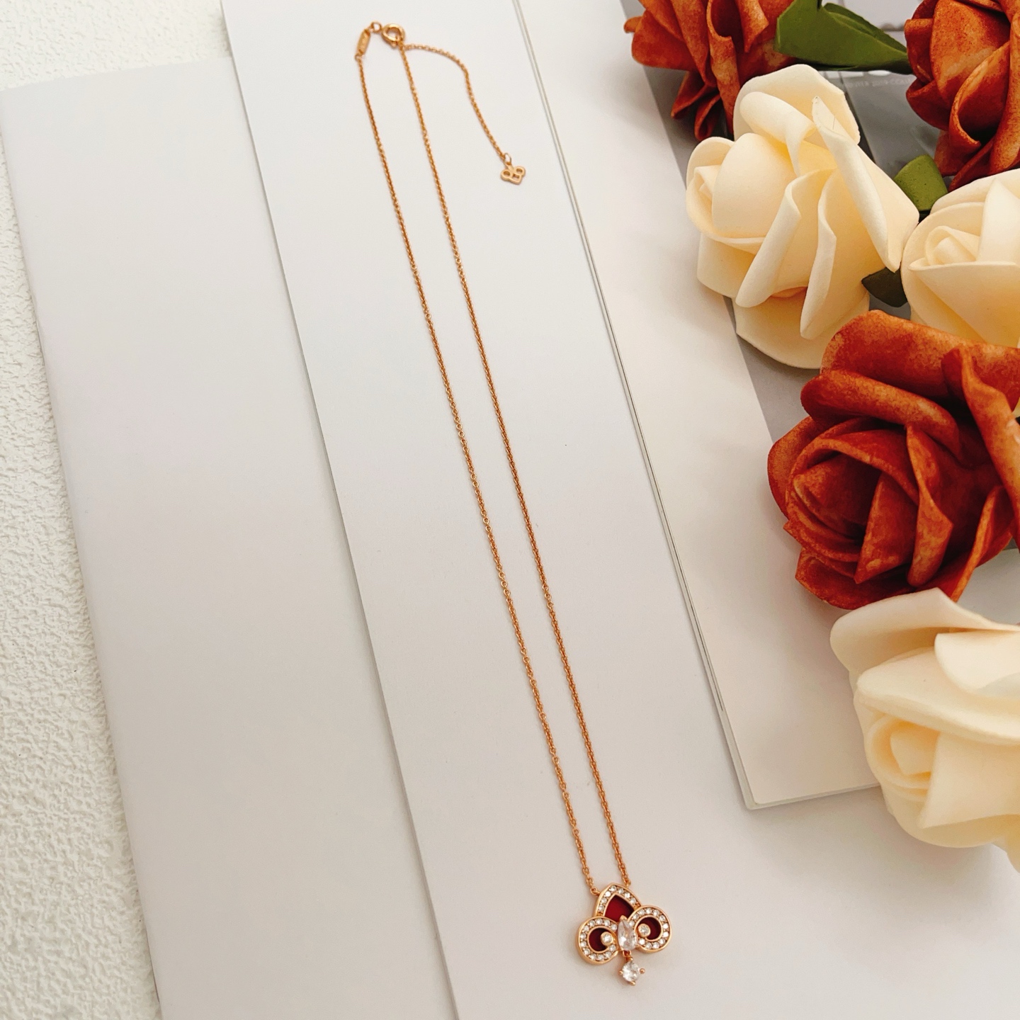 Tiffany Co Fleur de Lis Key Pendant Necklace necklace Rose gold metal with red carnelian inlay and clear diamond accents 45cm