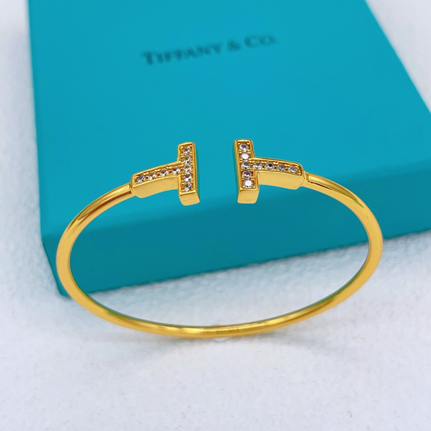 Tiffany Co T Wire bracelet gold metal with clear diamond accents 17cm inner circumference