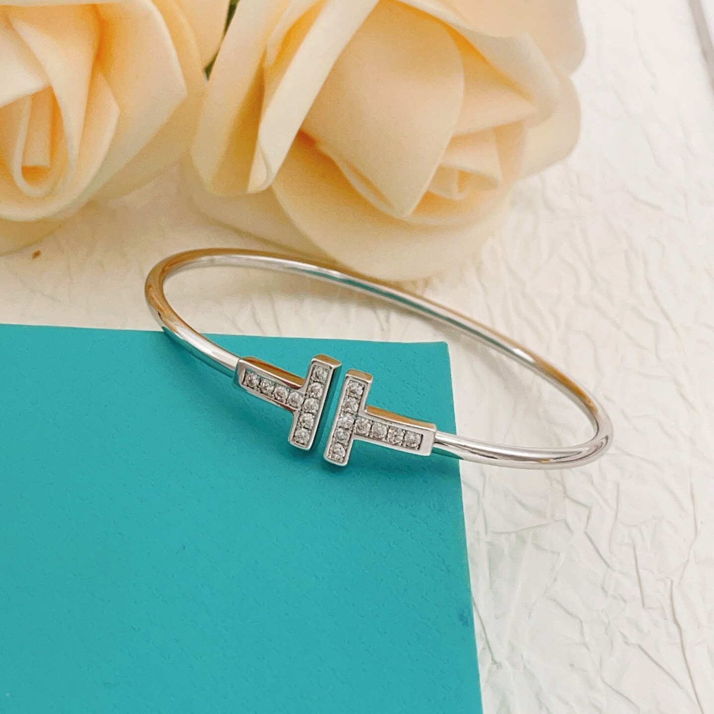 Tiffany Co T Wire bracelet Sterling silver metal with clear diamond accents also available in 18k yellow gold and 18k rose gold metal with clear diamond accents 17cm inner circumference