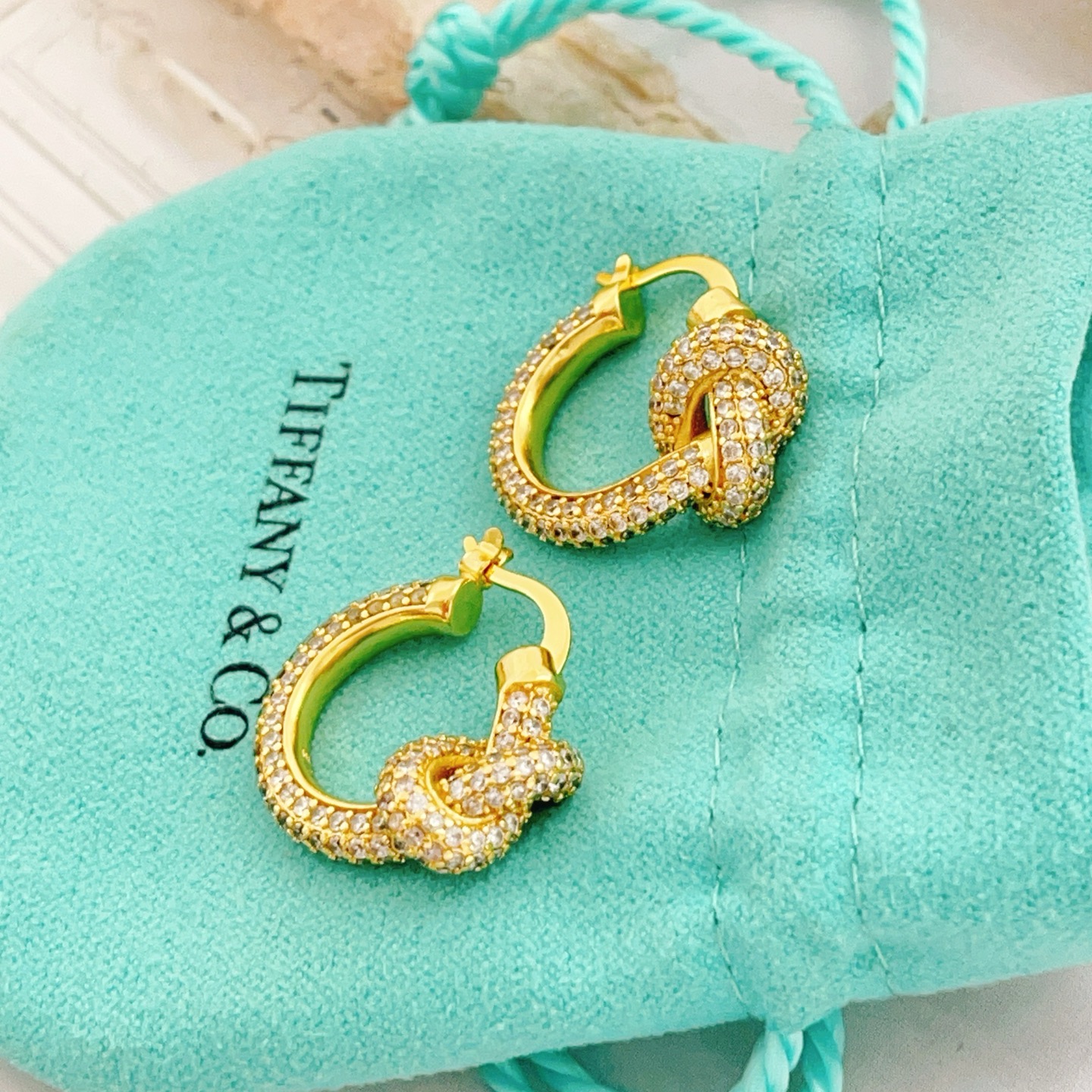 Tiffany Co Knot earrings yellow gold metal with clear pave diamonds 15mm hoop diameter