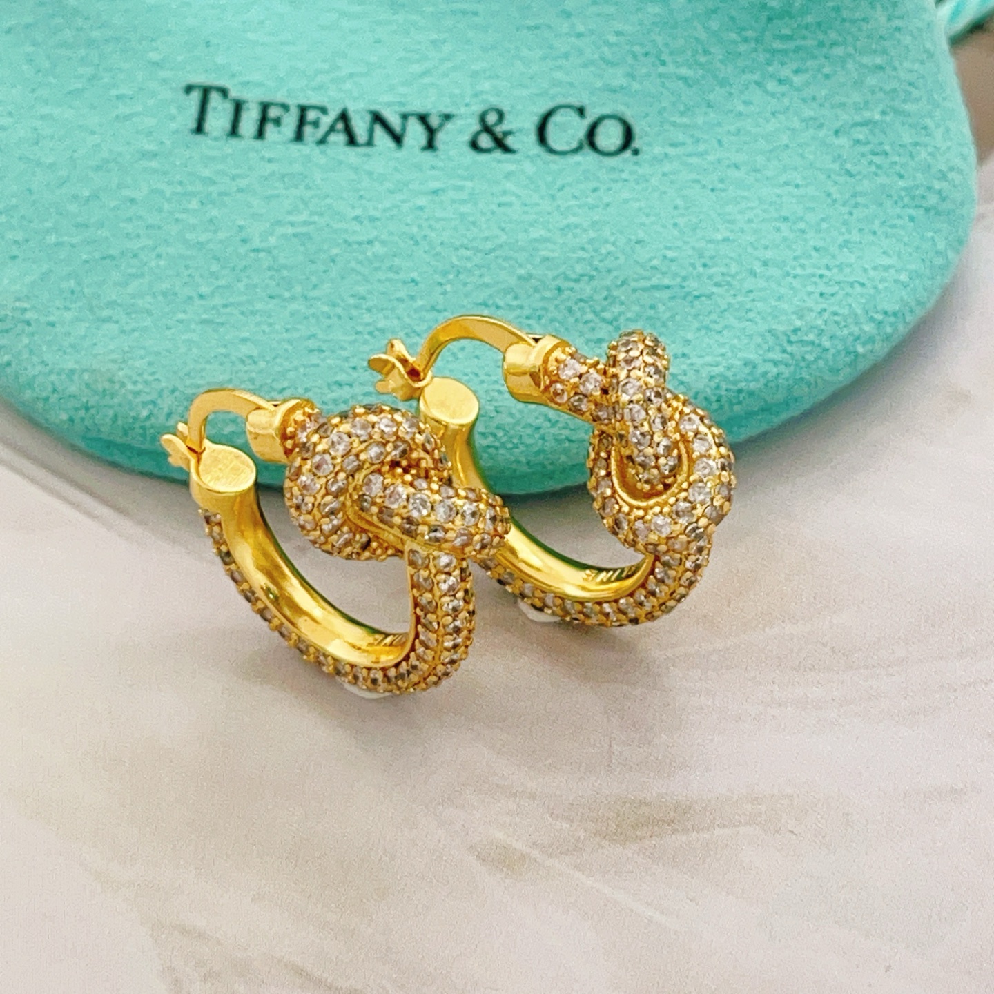 Tiffany Co Knot earrings yellow gold metal with clear pave diamonds 15mm hoop diameter