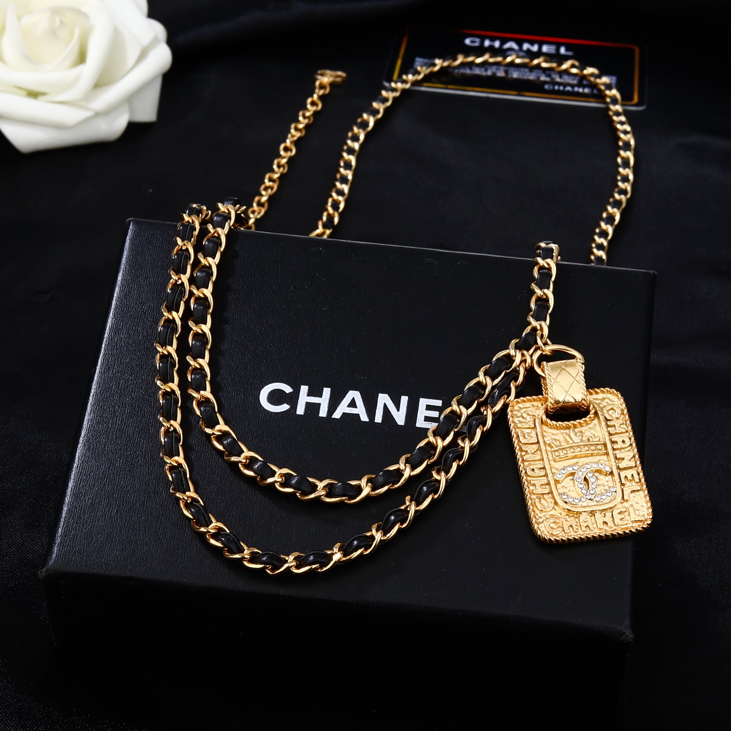 Chanel Goose series necklace gold-tone metal with black leather woven chain clear crystal accents on gold-tone pendant 80cm