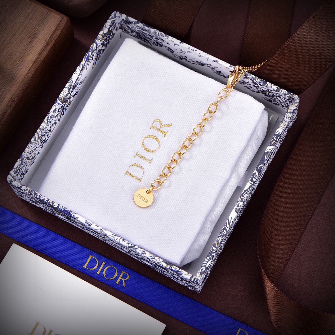 Dior Petit CD necklace Gold-toned metal with black glass center and white resin pearl accents 42cm