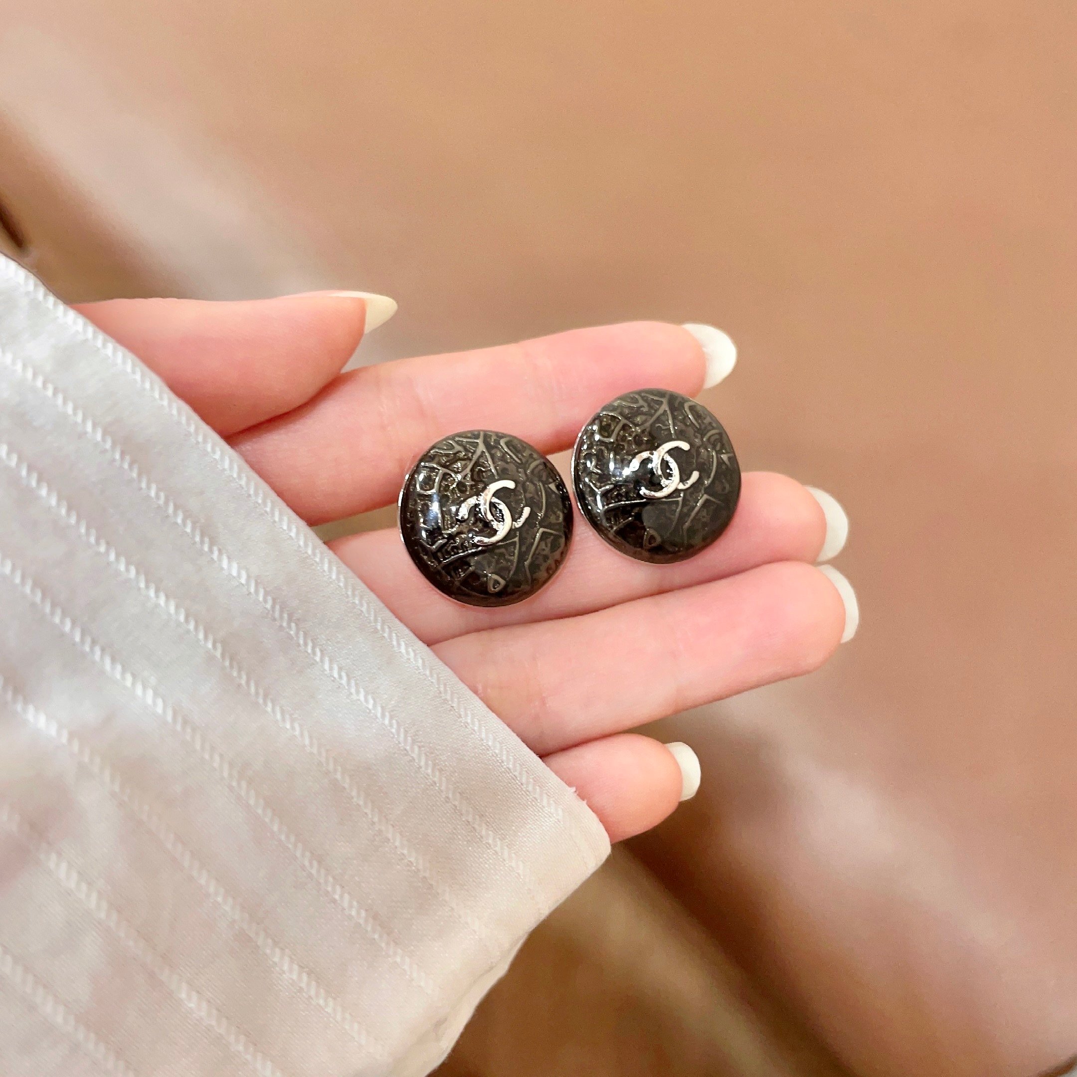 Chanel CC Logo Round Button Stud Earrings earrings ruthenium dark gunmetal with silver-tone interlocking CC logo dark translucent resin base with silver filigree detailing 1 5cm diameter