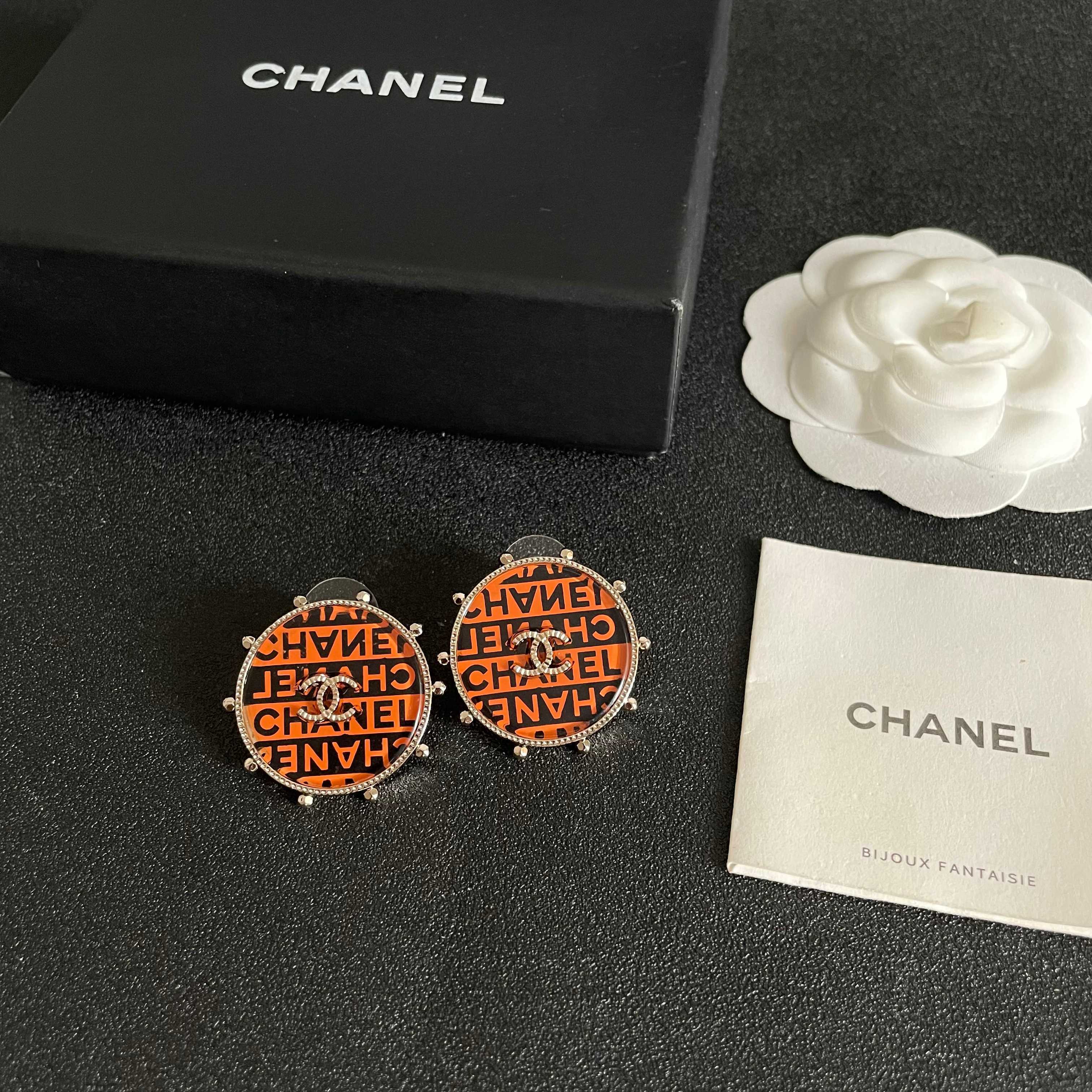 Chanel CC Logo Round Printed Stud Earrings earrings Gold-tone metal with clear crystal accents orange and black enamel printed with Chanel text 2 5cm diameter