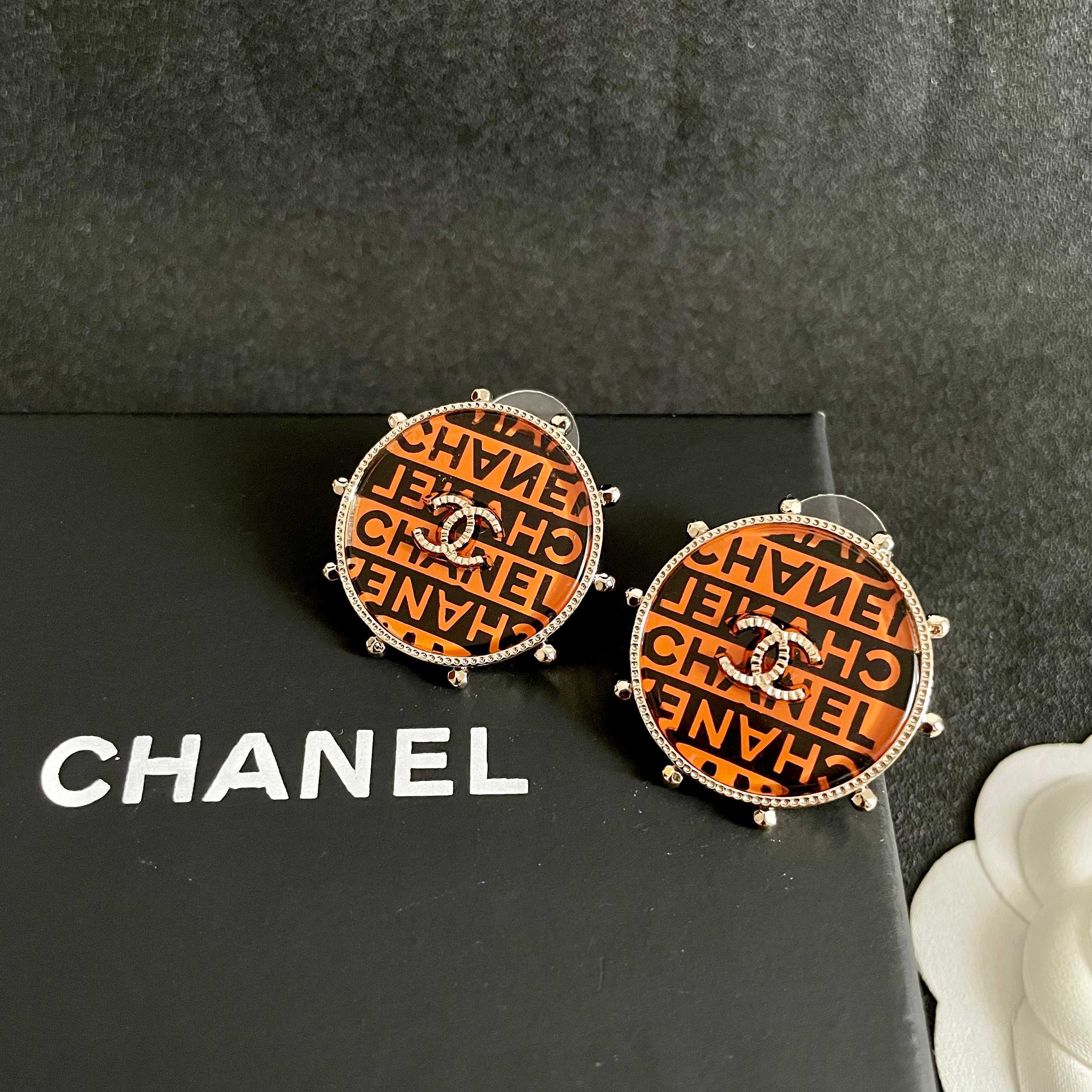 Chanel CC Logo Round Printed Stud Earrings earrings Gold-tone metal with clear crystal accents orange and black enamel printed with Chanel text 2 5cm diameter