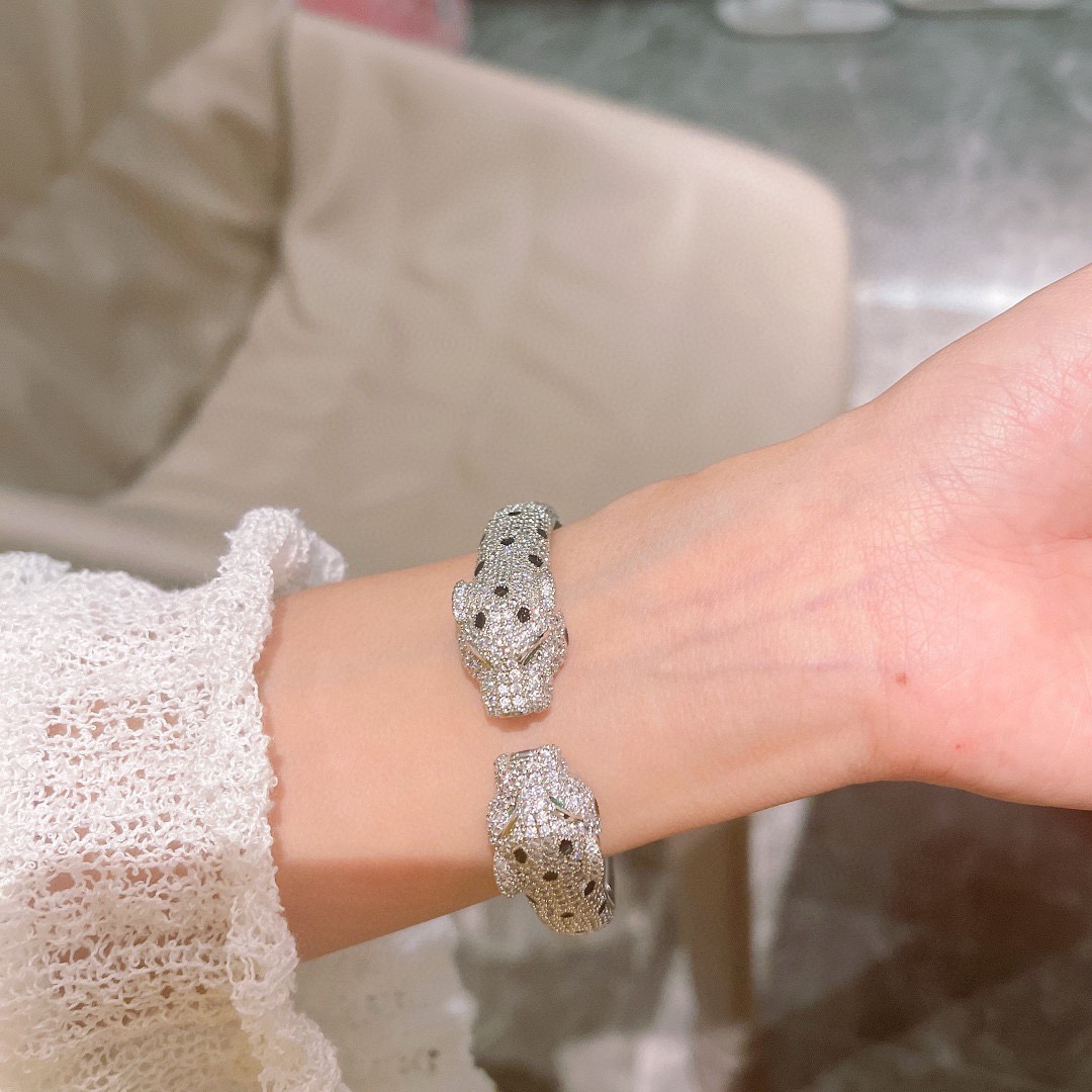 Cartier Panthere de Cartier bracelet Available in 18K white gold 18K rose gold 18K yellow gold fully paved with colorless diamonds black onyx spots green tsavorite garnet eyes 17cm