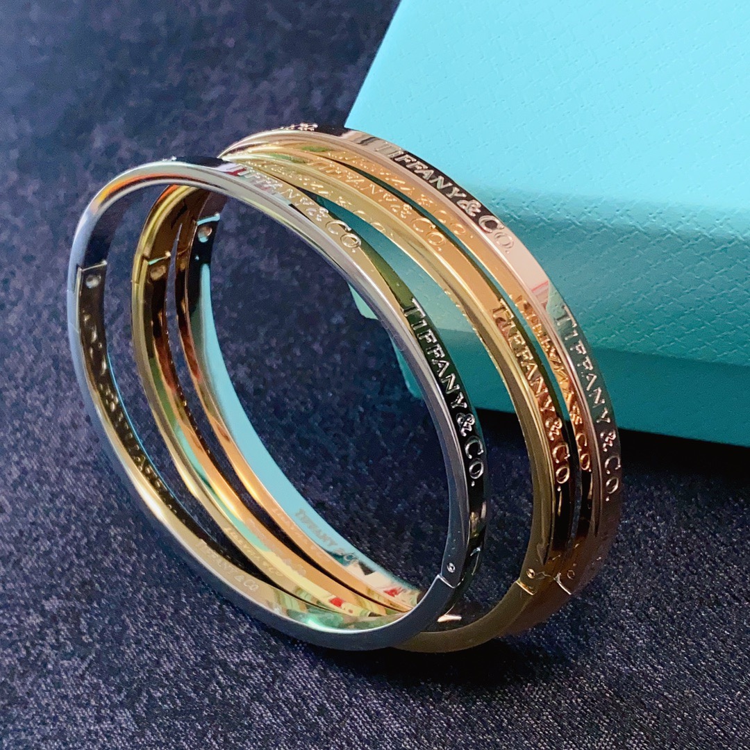 Tiffany Co Tiffany Logo Engraved Hinged Bangle bracelet Polished gold-tone metal no accent stones 17cm inner circumference