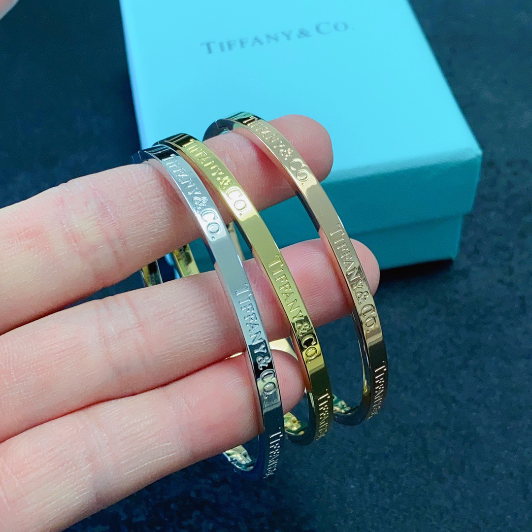 Tiffany Co Tiffany Logo Engraved Hinged Bangle bracelet Polished gold-tone metal no accent stones 17cm inner circumference