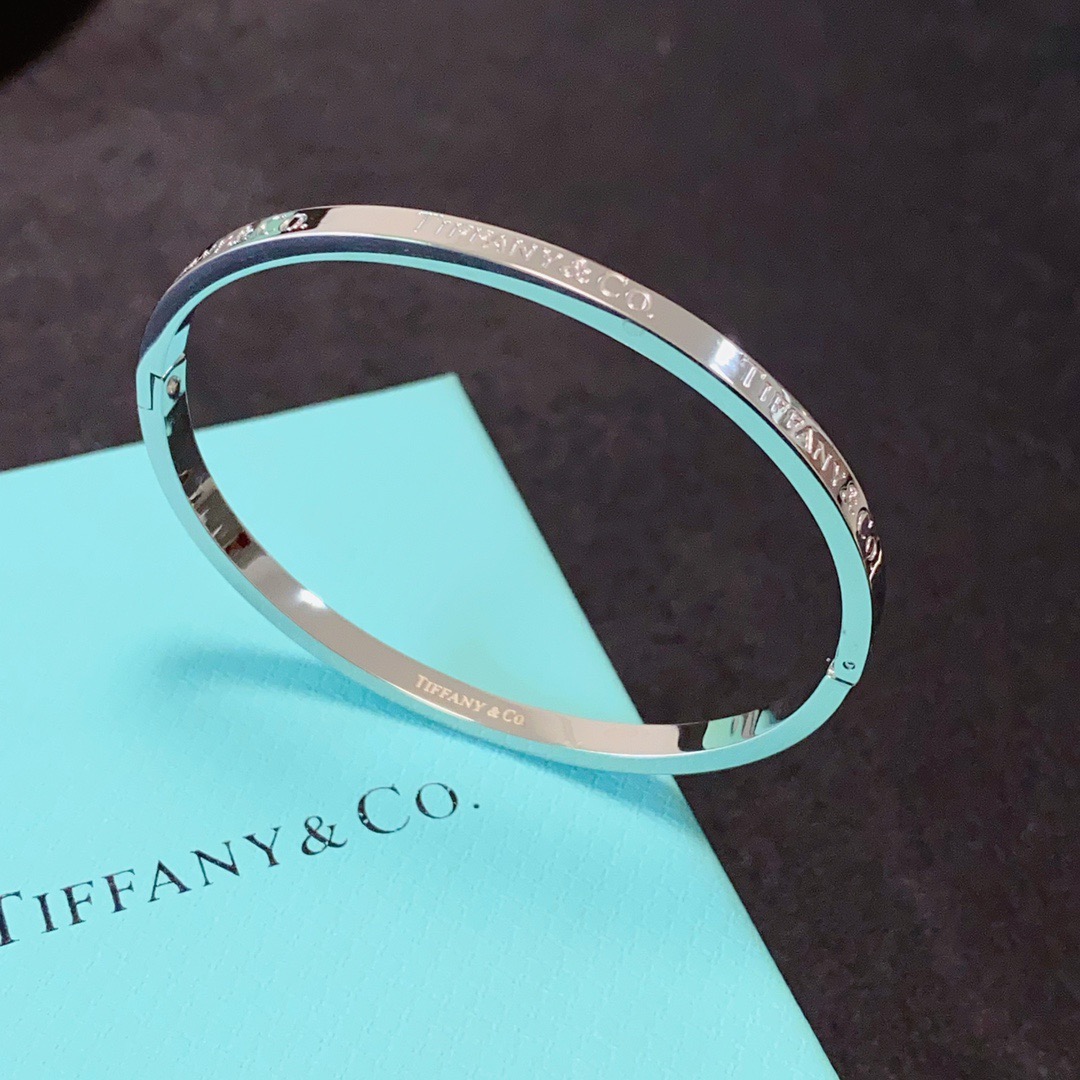 Tiffany Co Tiffany Logo Engraved Hinged Bangle bracelet Polished gold-tone metal no accent stones 17cm inner circumference
