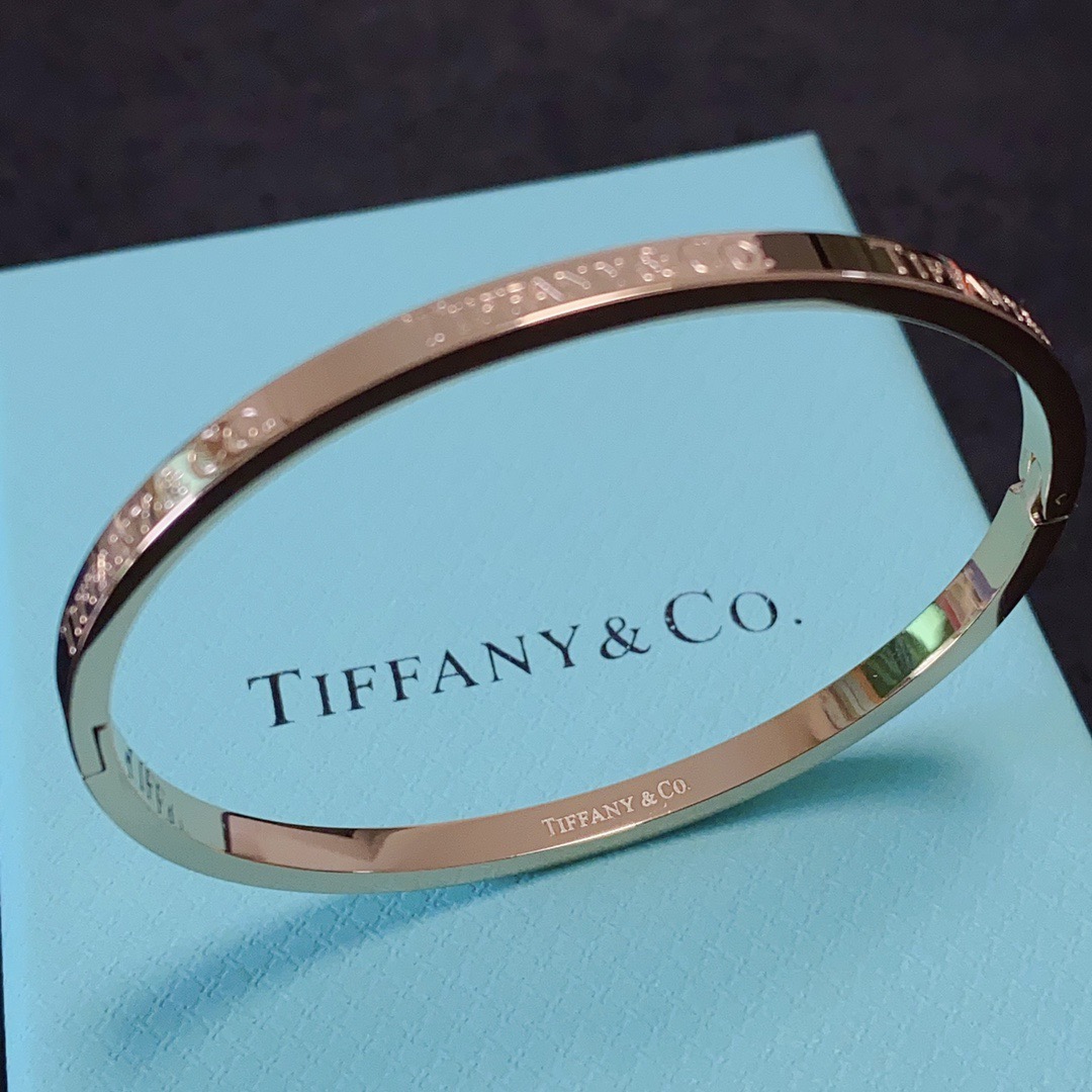Tiffany Co Tiffany Logo Engraved Hinged Bangle bracelet Polished gold-tone metal no accent stones 17cm inner circumference