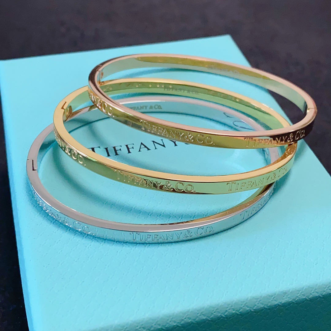 Tiffany Co Tiffany Logo Engraved Hinged Bangle bracelet Polished gold-tone metal no accent stones 17cm inner circumference