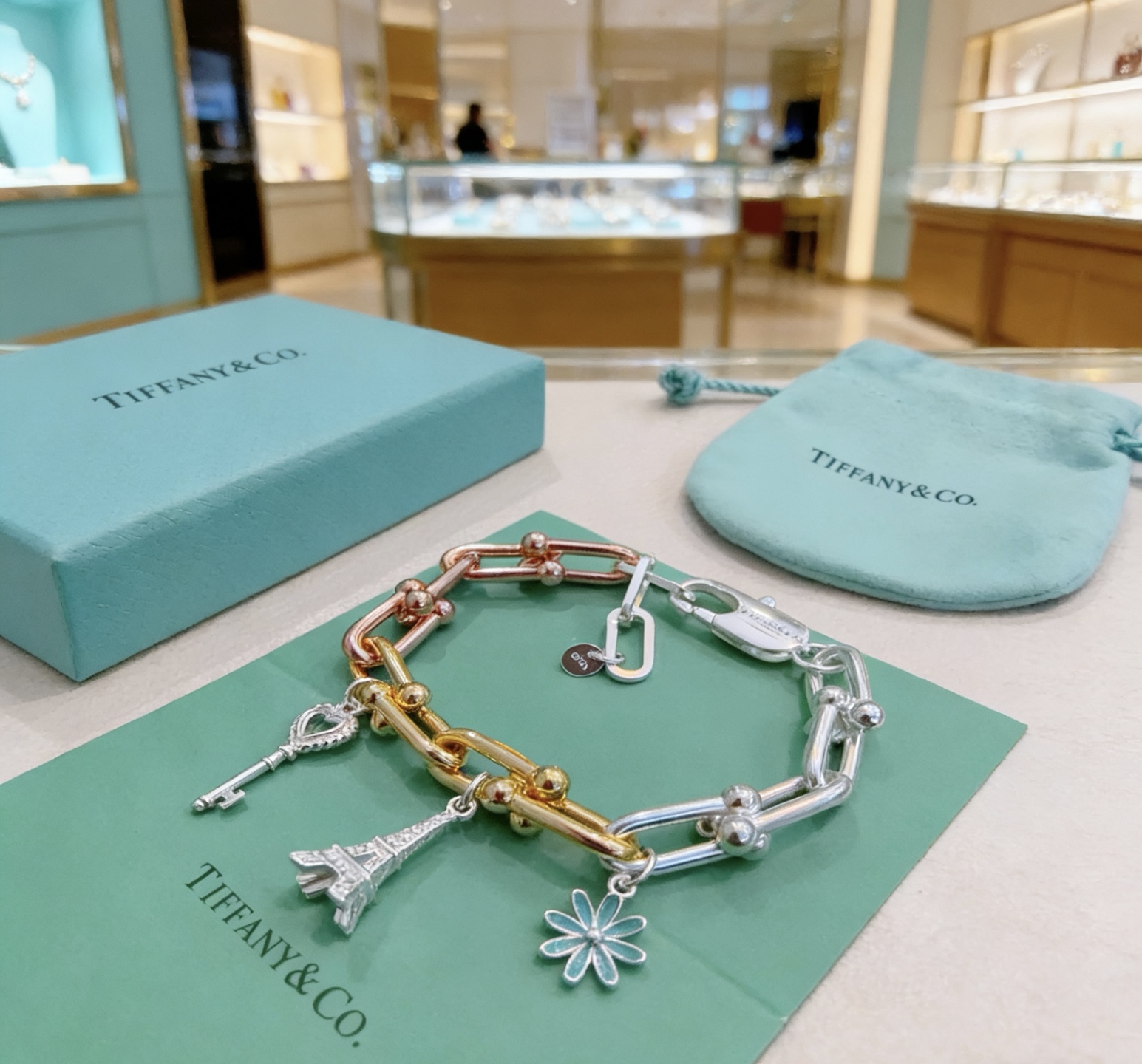 Tiffany Co HardWear Charm Bracelet bracelet Tri-tone sterling silver 18k yellow gold 18k rose gold metal with blue enamel daisy silver key charm silver Eiffel Tower charm 7 inches