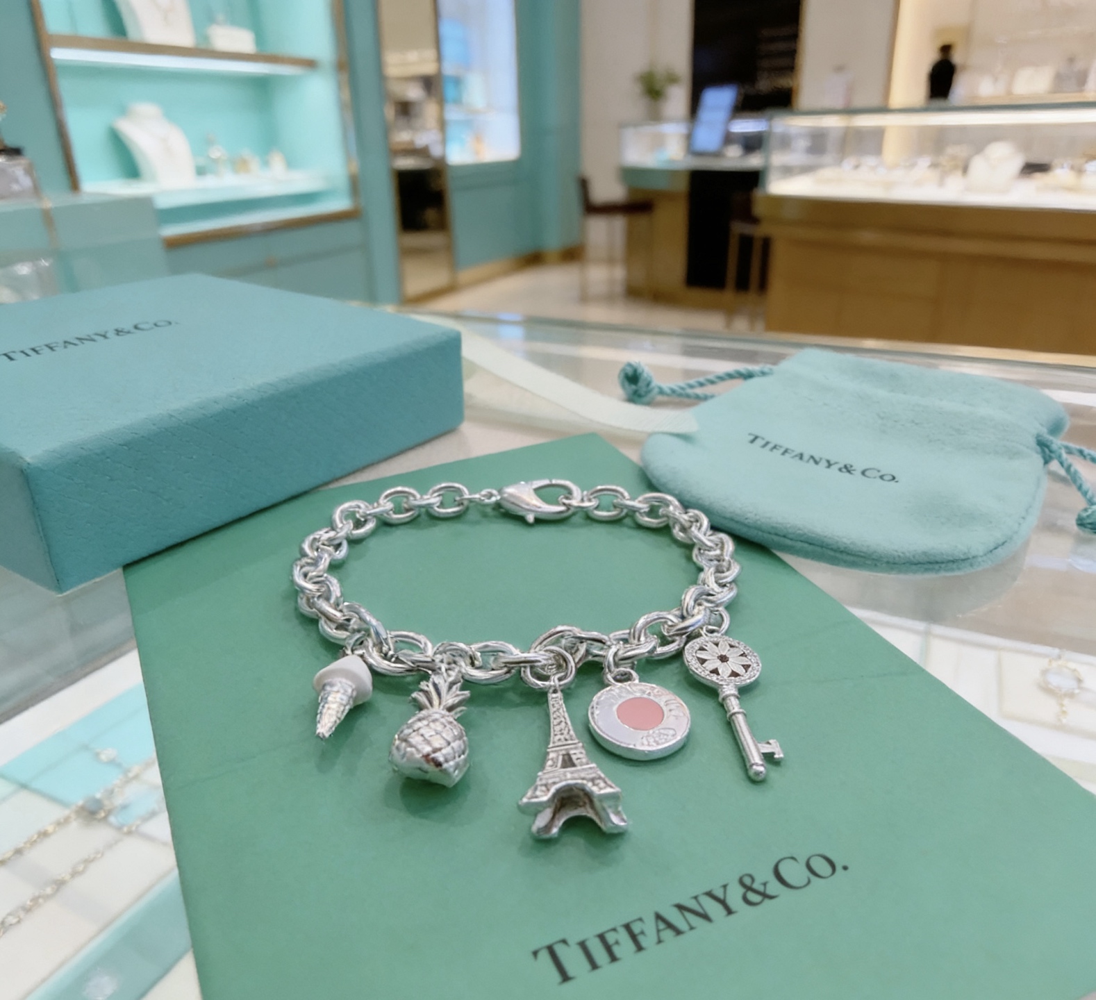 Tiffany Co Charm Bracelet bracelet Sterling silver with white enamel ice cream pink enamel round charm silver-toned pineapple Eiffel Tower and daisy key charms 7 inches