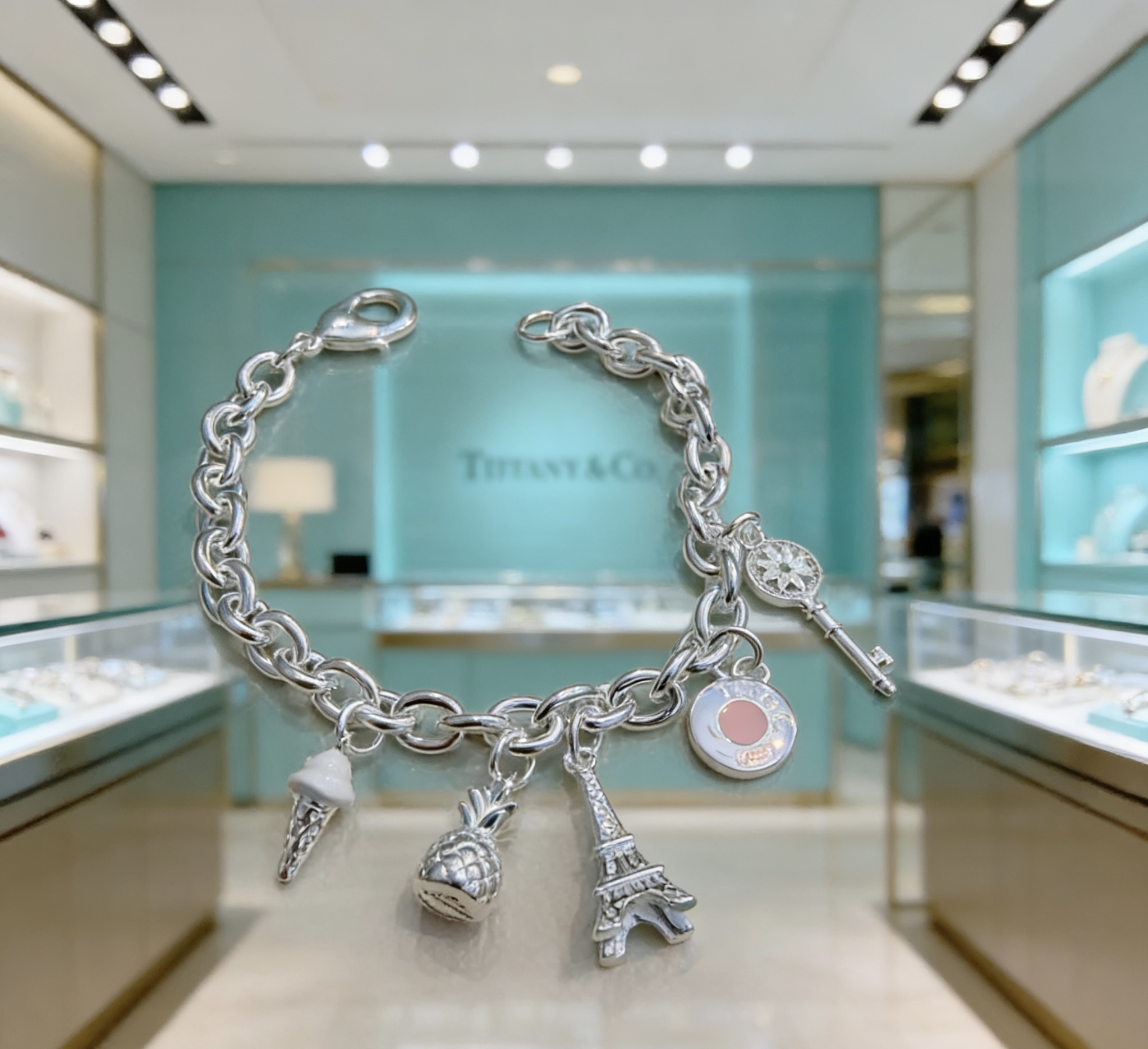 Tiffany Co Charm Bracelet bracelet Sterling silver with white enamel ice cream pink enamel round charm silver-toned pineapple Eiffel Tower and daisy key charms 7 inches