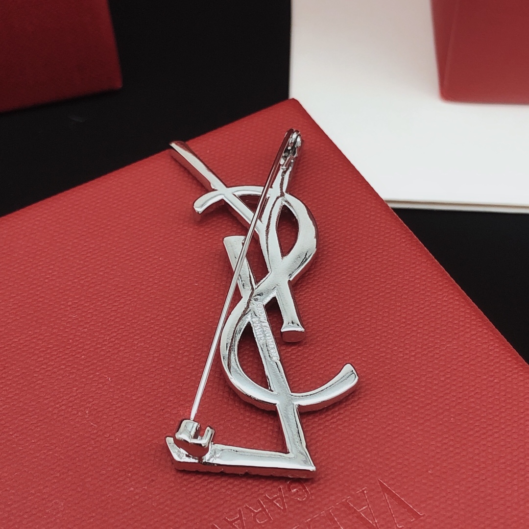 Saint Laurent Cassandre Twisted Monogram brooch silver tone metal no gemstones 4 5cm height