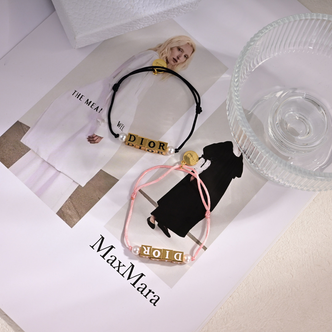 Dior D-Dice bracelet gold-tone metal with white resin beads available with black or light pink cotton cord adjustable sliding knot