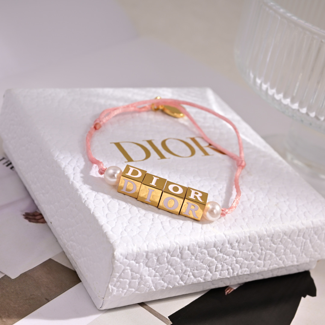 Dior D-Dice bracelet gold-tone metal with white resin beads available with black or light pink cotton cord adjustable sliding knot