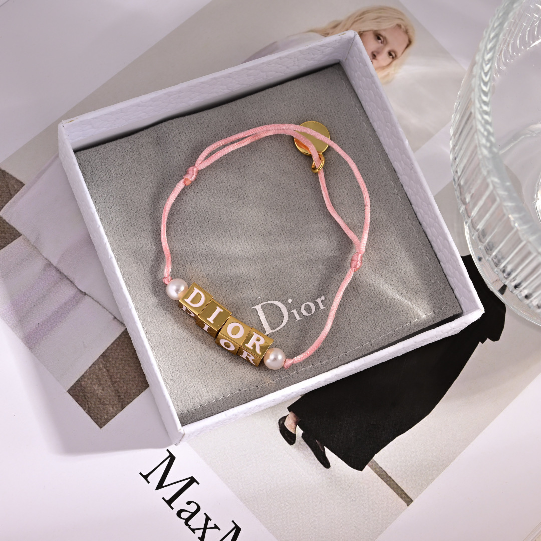 Dior D-Dice bracelet gold-tone metal with white resin beads available with black or light pink cotton cord adjustable sliding knot