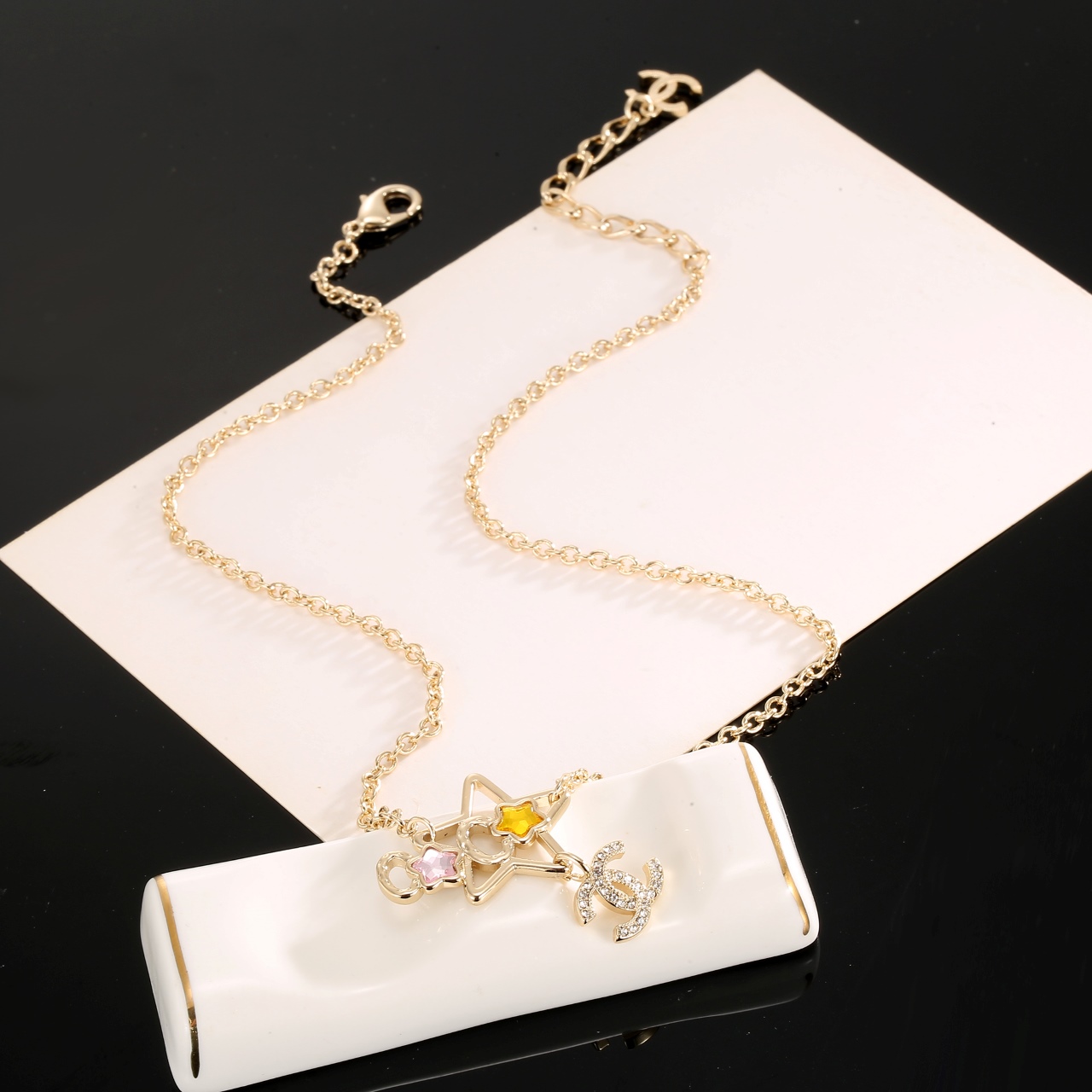 Chanel CC Star Charm necklace gold-tone metal with clear crystals pink and yellow star accents 42cm with 5cm extender